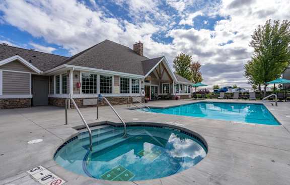 A small pool with a slide in front of a house.
