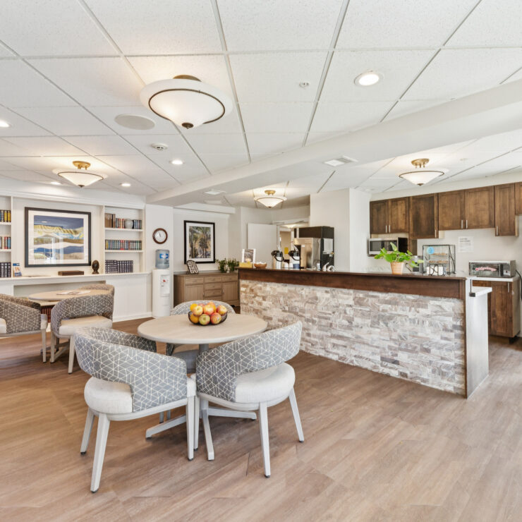 Bright and inviting community room with seating, kitchen area, and warm decor for social gatherings.