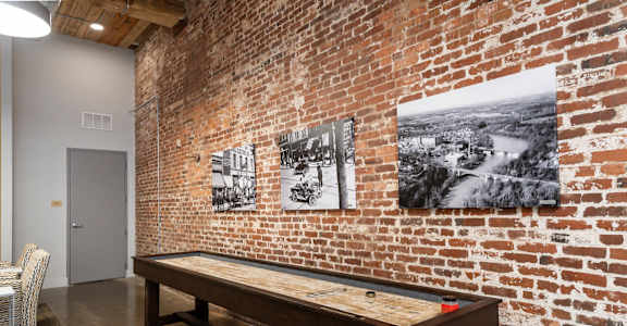 A room with a brick wall and a billiard table.