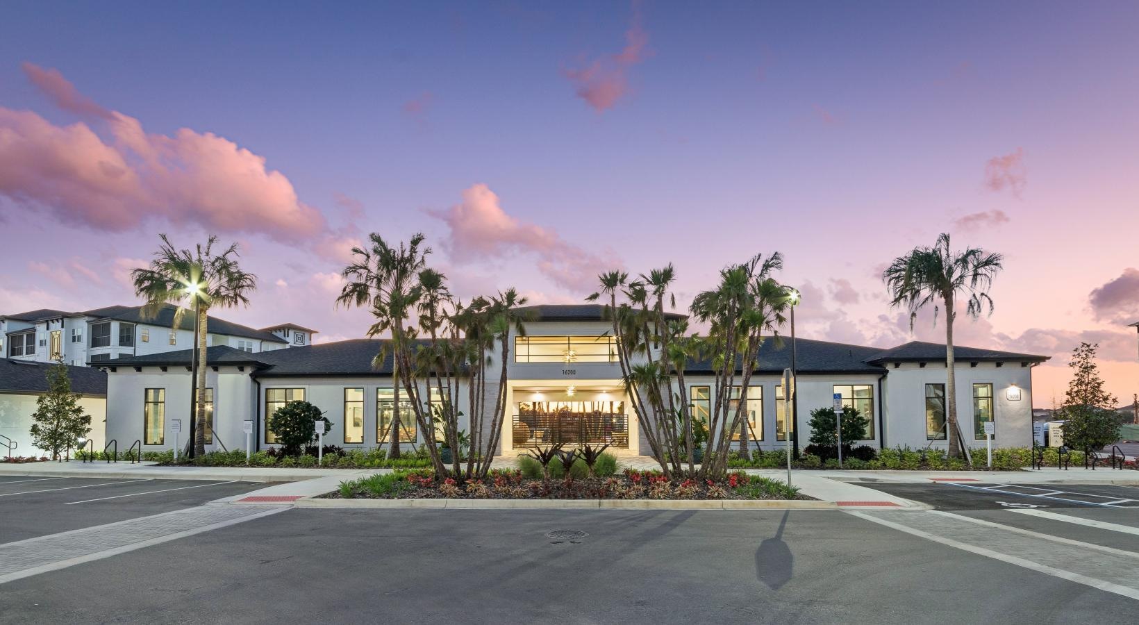 front of a white building with palm trees