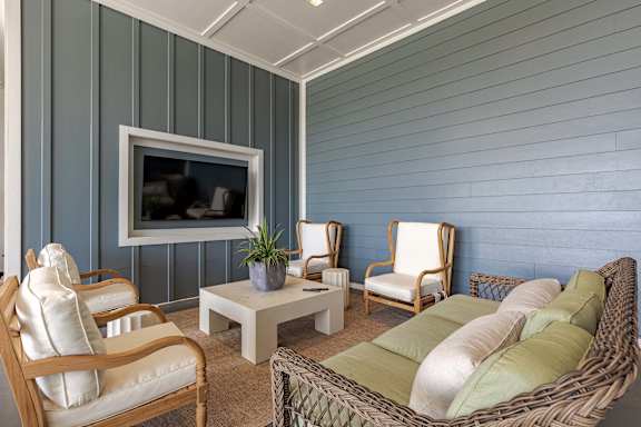 Living room area with wooden tables, chairs, and a TV.