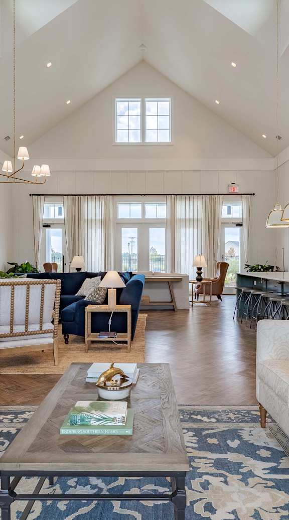 Furnished living room with high ceilings, large window, and stylish decor.