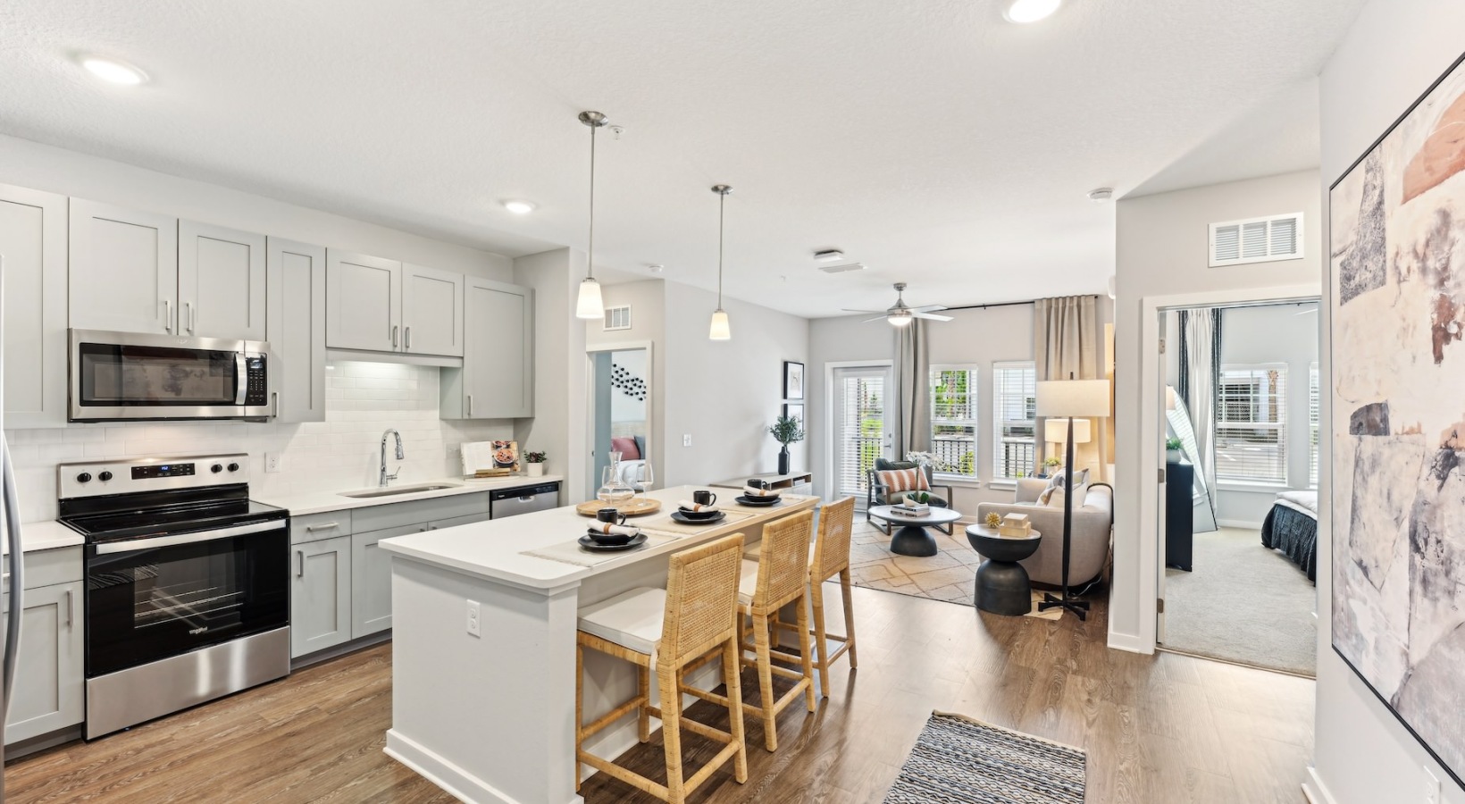 Kitchen island with hanging light fixture connected to a living room