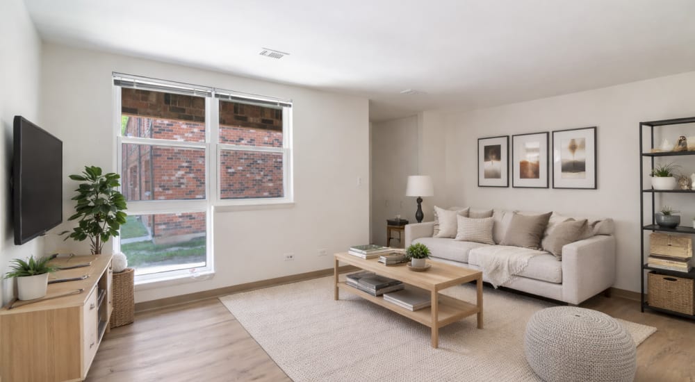 Living room with large windows featuring hardwood flooring at BJ Wright Court Apartments in Chicago, Illinois