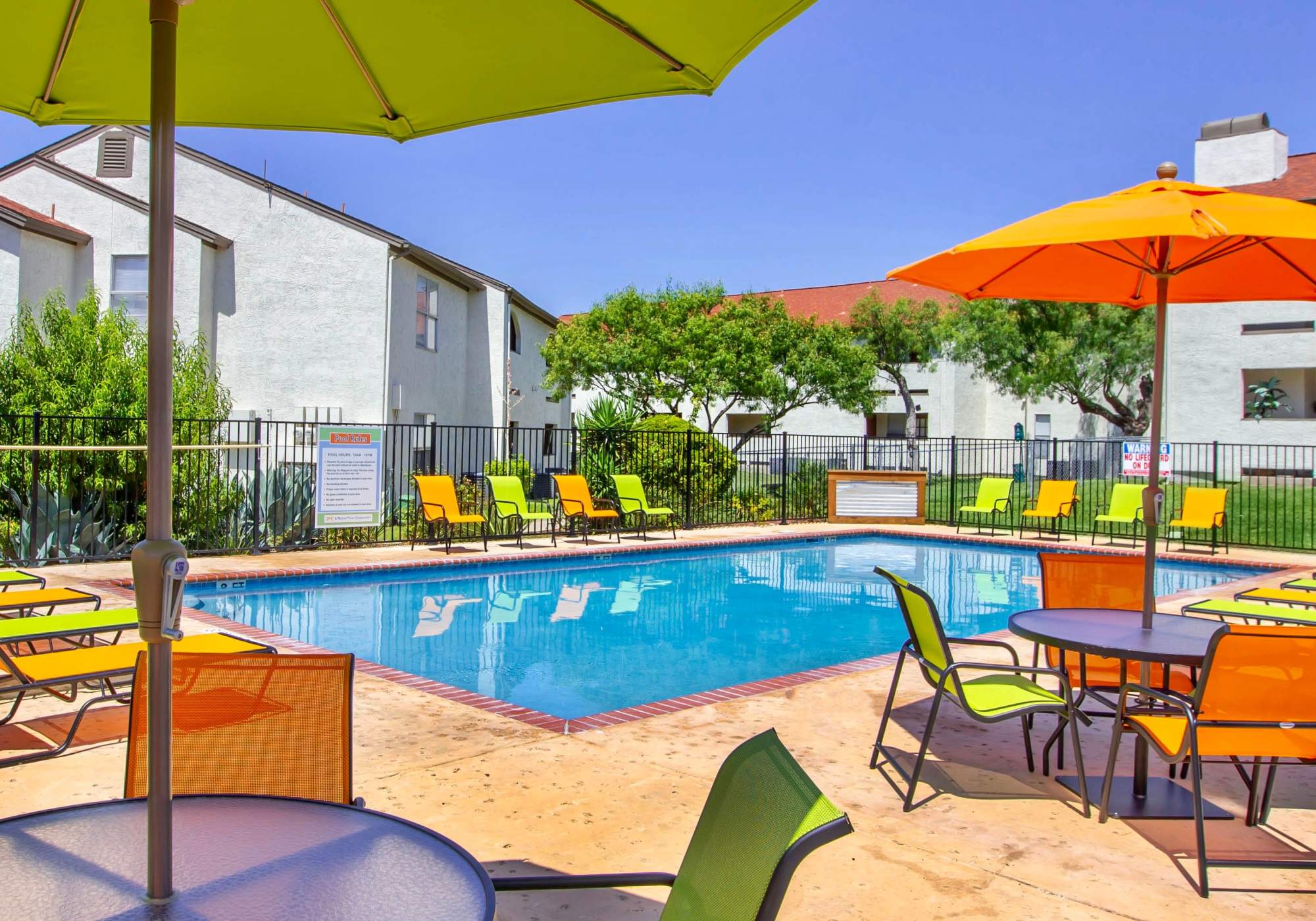 Colorful chairs surrounding the swimming pool at Villas de Toscana in San Antonio, Texas