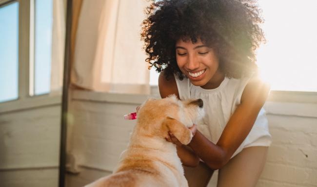 a woman playing with her dog