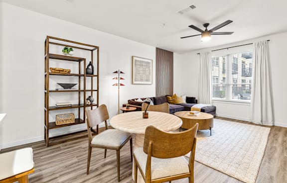 A modern kitchen with white cabinets and a checkered rug on the floor.