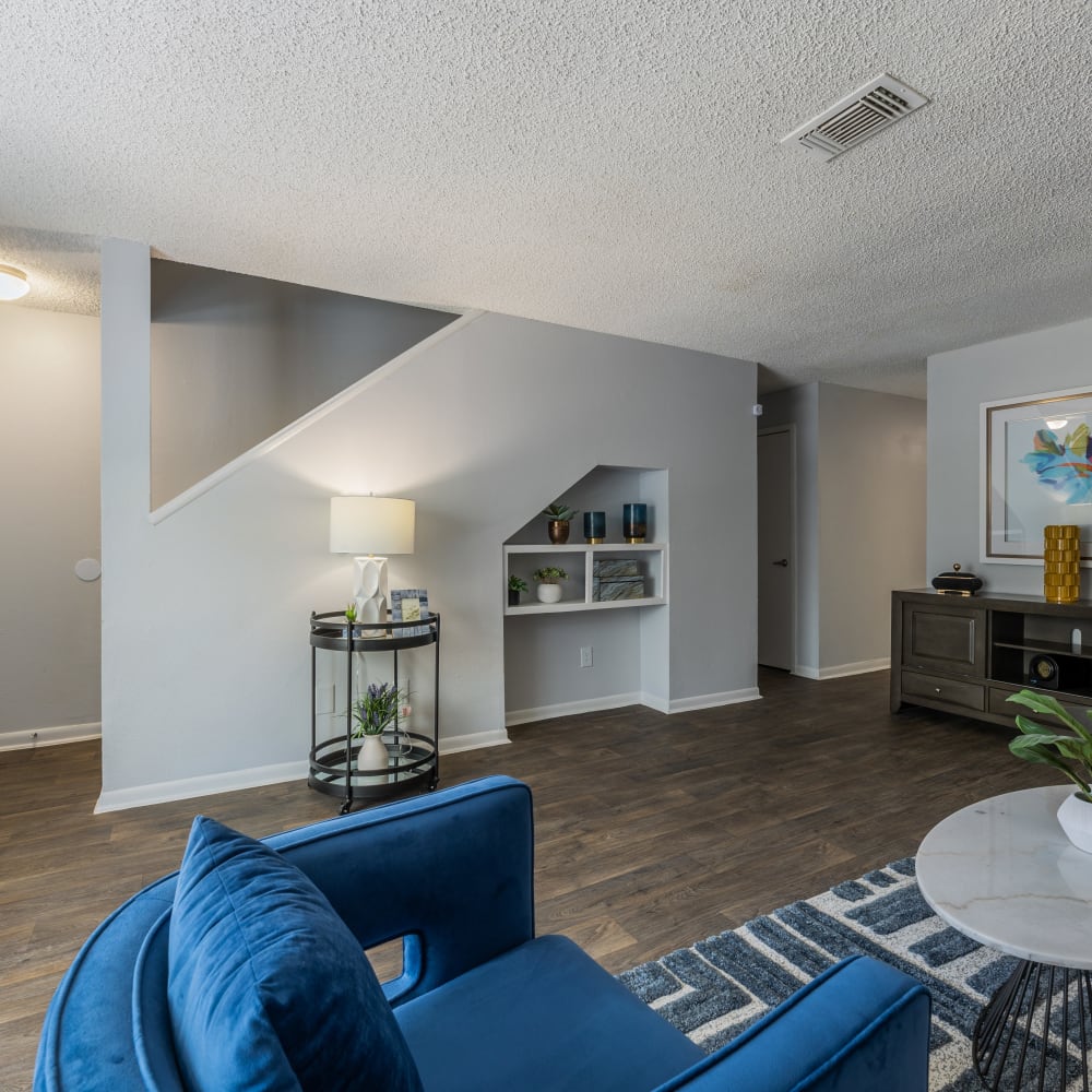 a living room with blue furniture and stairs at The Lakebridge Townhomes