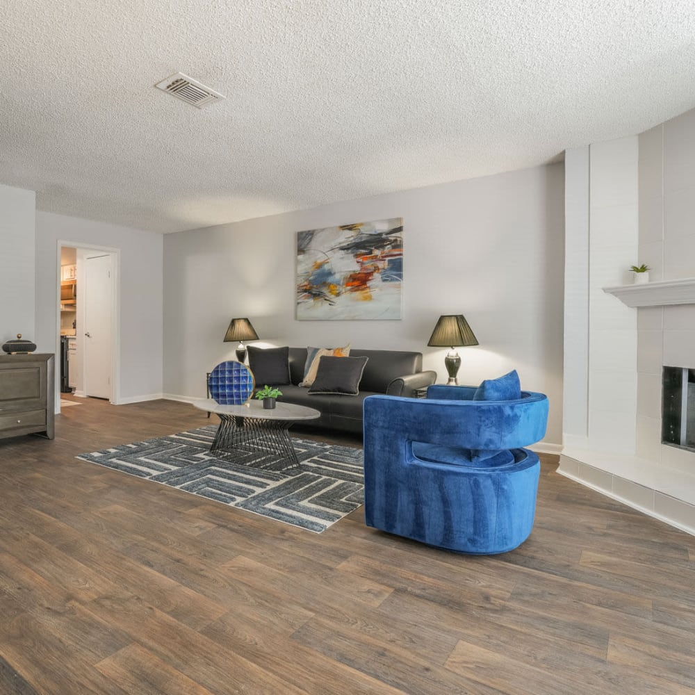 a living room with blue furniture and hardwood floors at The Lakebridge Townhomes