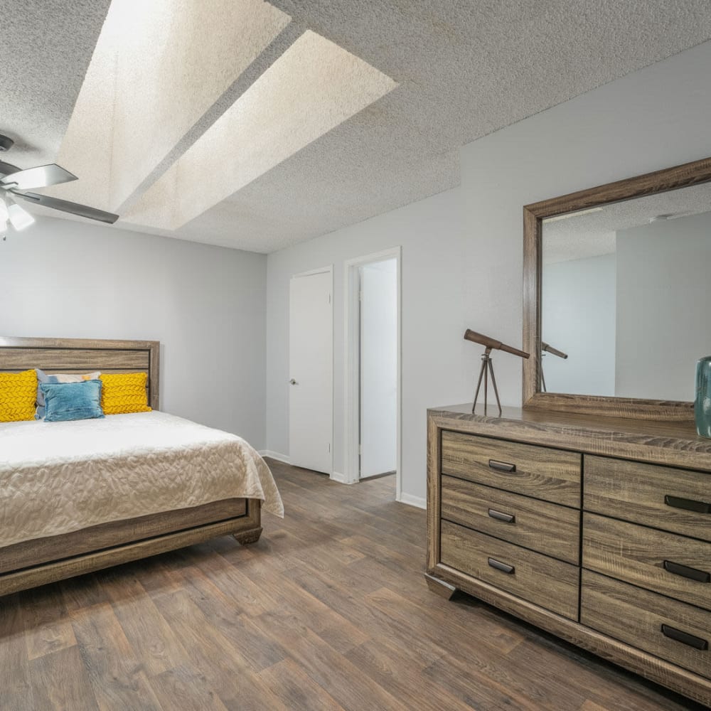 a bedroom with a ceiling fan and hardwood floors at The Lakebridge Townhomes