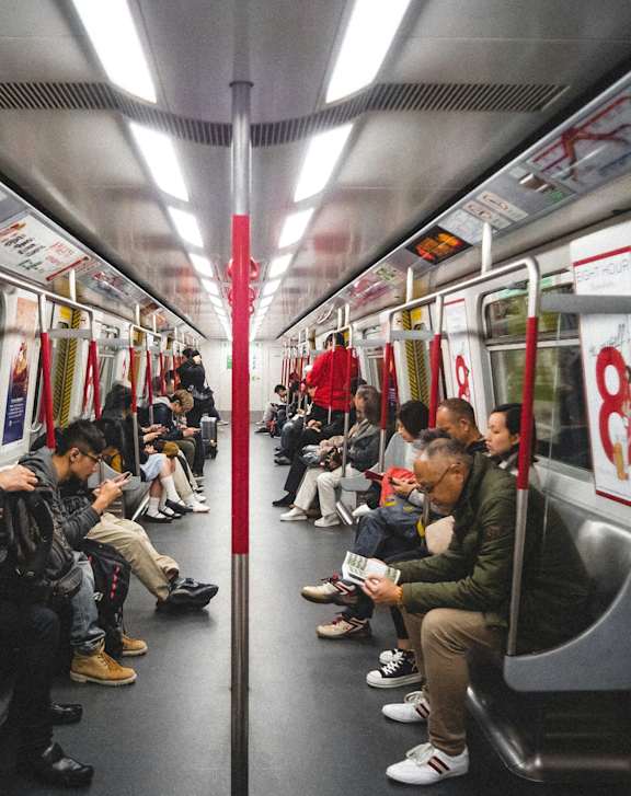 A subway train with people sitting on the seats.