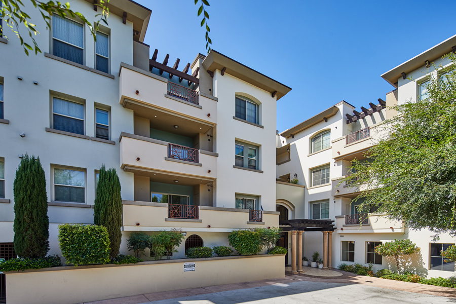 white mesa style building with a modern clay trim and organized planters lining the property
