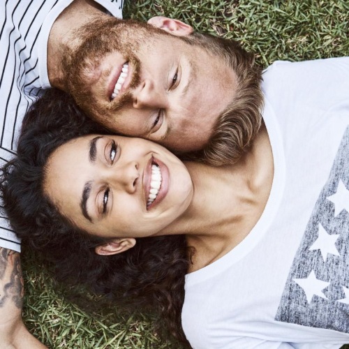 a man and woman lying in the grass