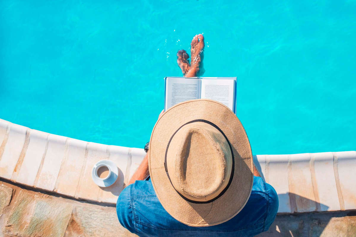 A resident reading a book by the community pool at Trailwood Crossing Apartments, Raleigh, North Carolina 