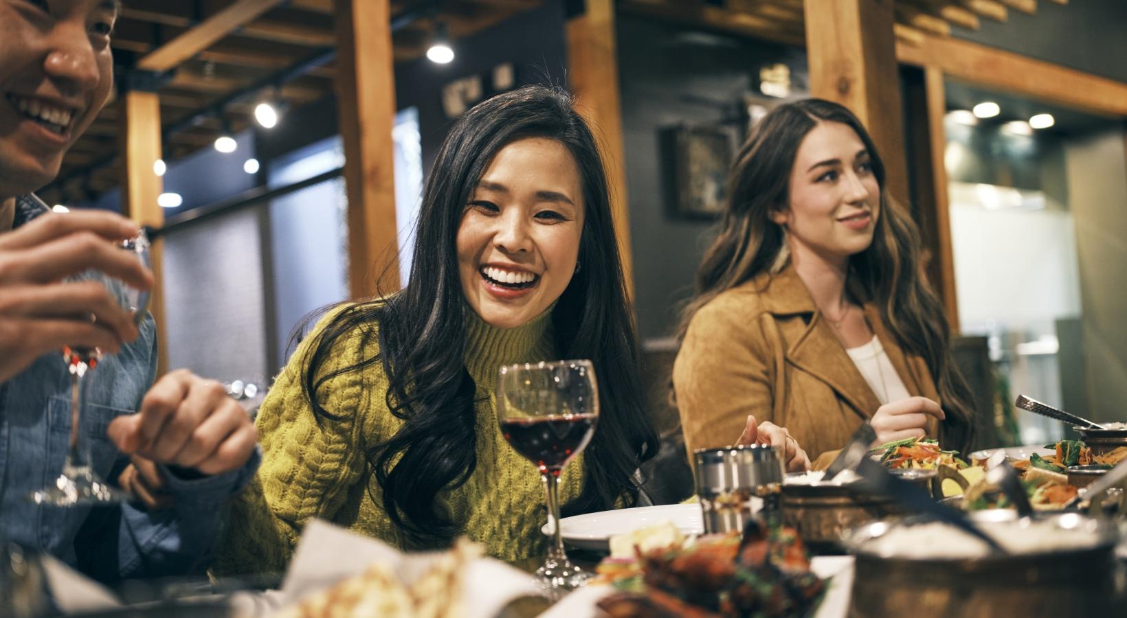 a group of people sitting at a table with food and drinks