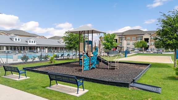 A playground with a slide and two benches.