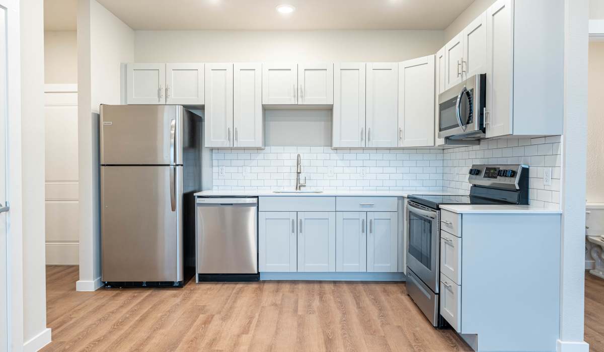 Kitchen with quartz countertops and trendy appliances at Pure Lowell Apartments in Lowell, Arkansas
