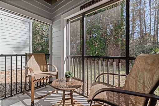 A balcony with a table and two chairs.