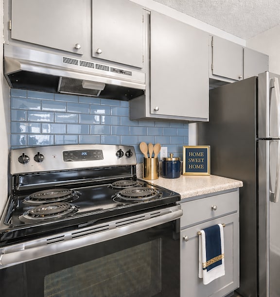 A kitchen with a stove, oven, and refrigerator.