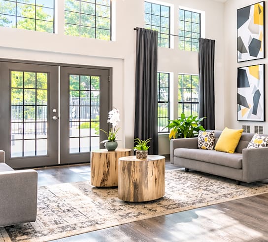 A modern living room with a grey sofa, a white chair, and a wooden coffee table.