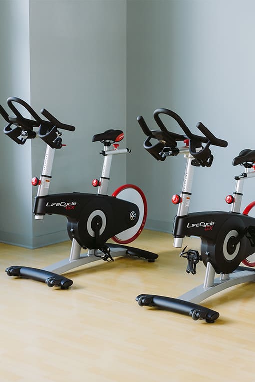 a workout room with treadmills and a tv