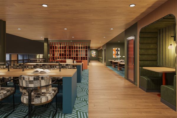 Modern, cozy workspace with patterned chairs, booth seating, wood floors, and colorful decor.
