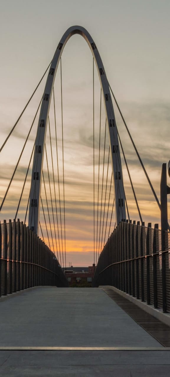 A bridge with a white walkway and a metal railing.