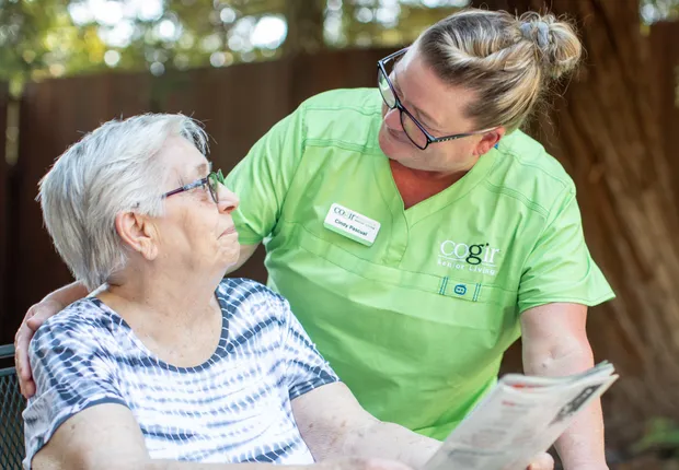 A caregiver warmly connects with a resident, fostering a sense of community and comfort outdoors.