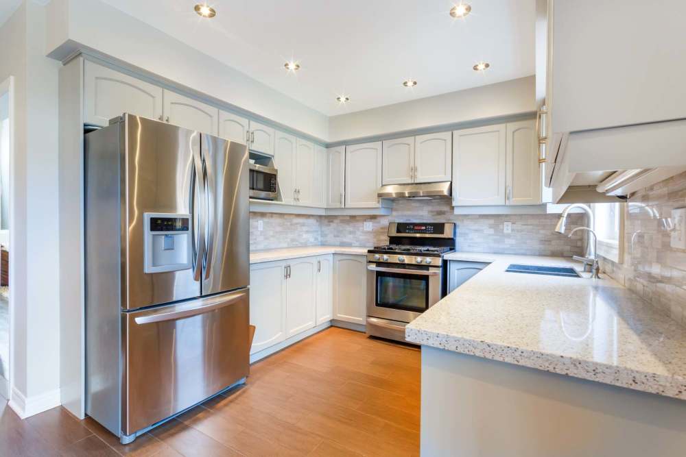 Kitchen with appliances and hard wood flooring at Reeds Landing Apartments in Edmond, Oklahoma  