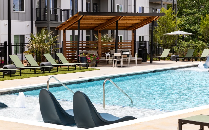 Resort-style pool with sundeck & pergolas at Ava Oakwood apartments for rent in Gainesville, GA.