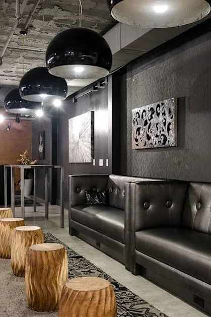 A modern living room with a grey sofa and wooden stumps on the floor.
