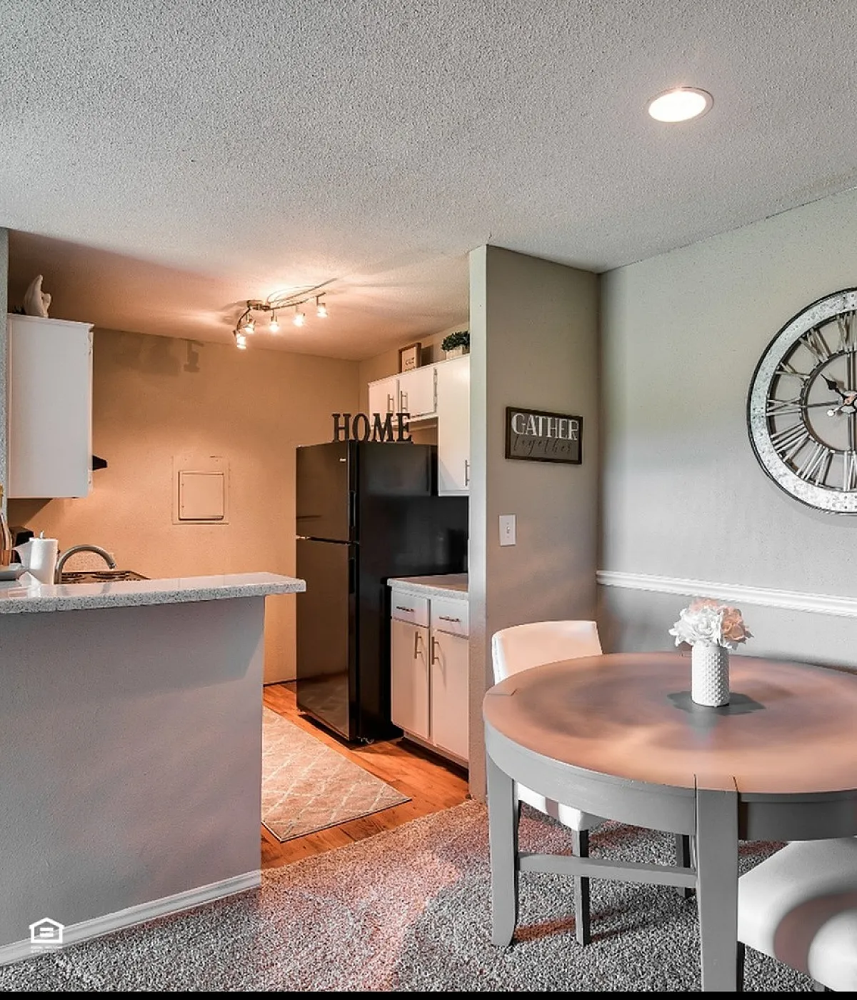 Charming apartment interior featuring a cozy dining area with elegant seating, adjacent to a modern kitchen with sleek appliances and stylish decor.
