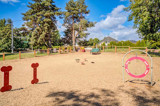 A playground with a pink ring and red posts.
