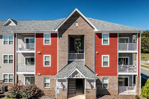 Exterior of Hawks Landing Apartments in Hickory, NC with red and gray building and clear blue sky