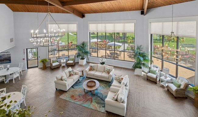 large lounge with seating tables and windows