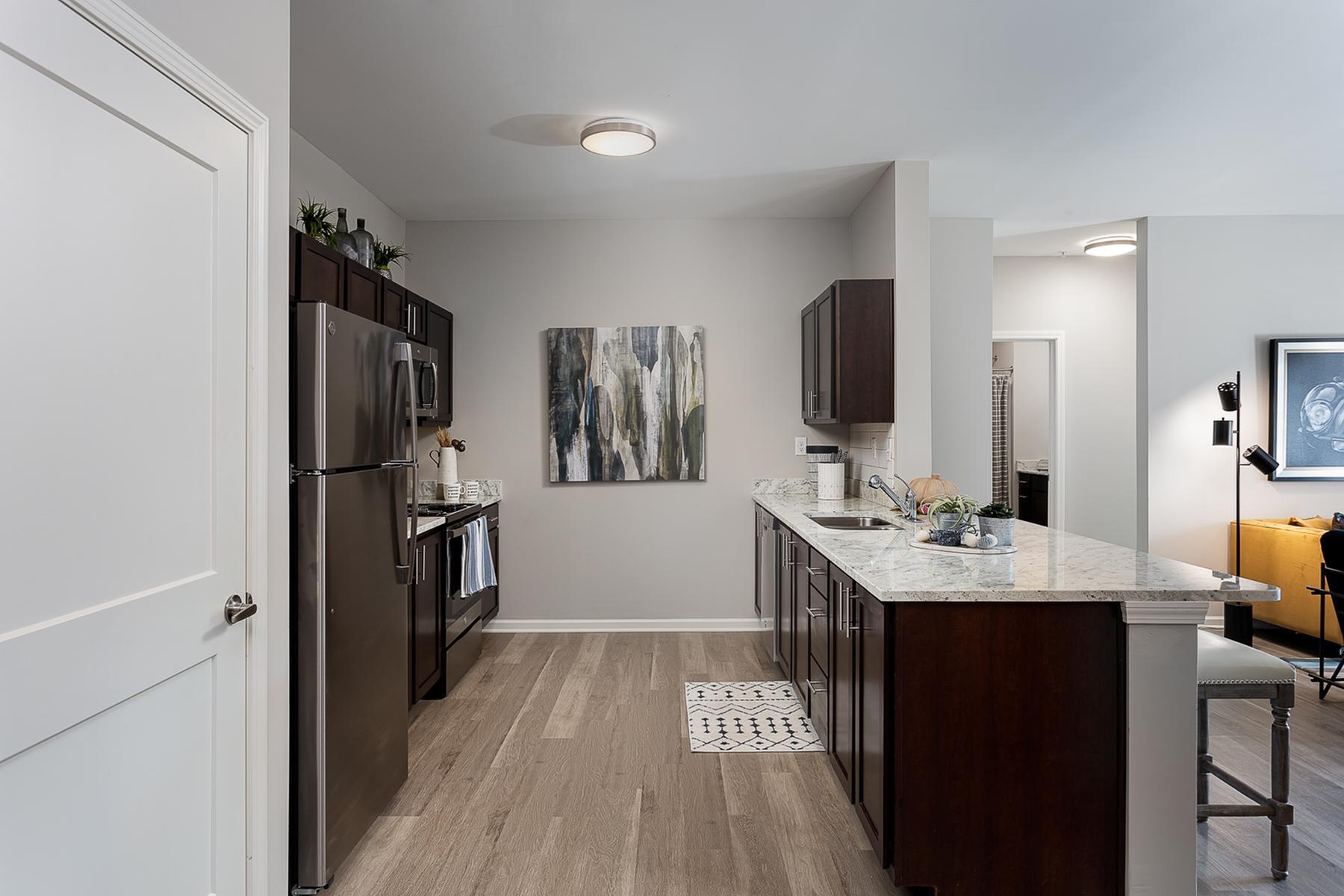 Model furnished kitchen with stainless steel appliances and granite countertops in a Moonlight Apartments home