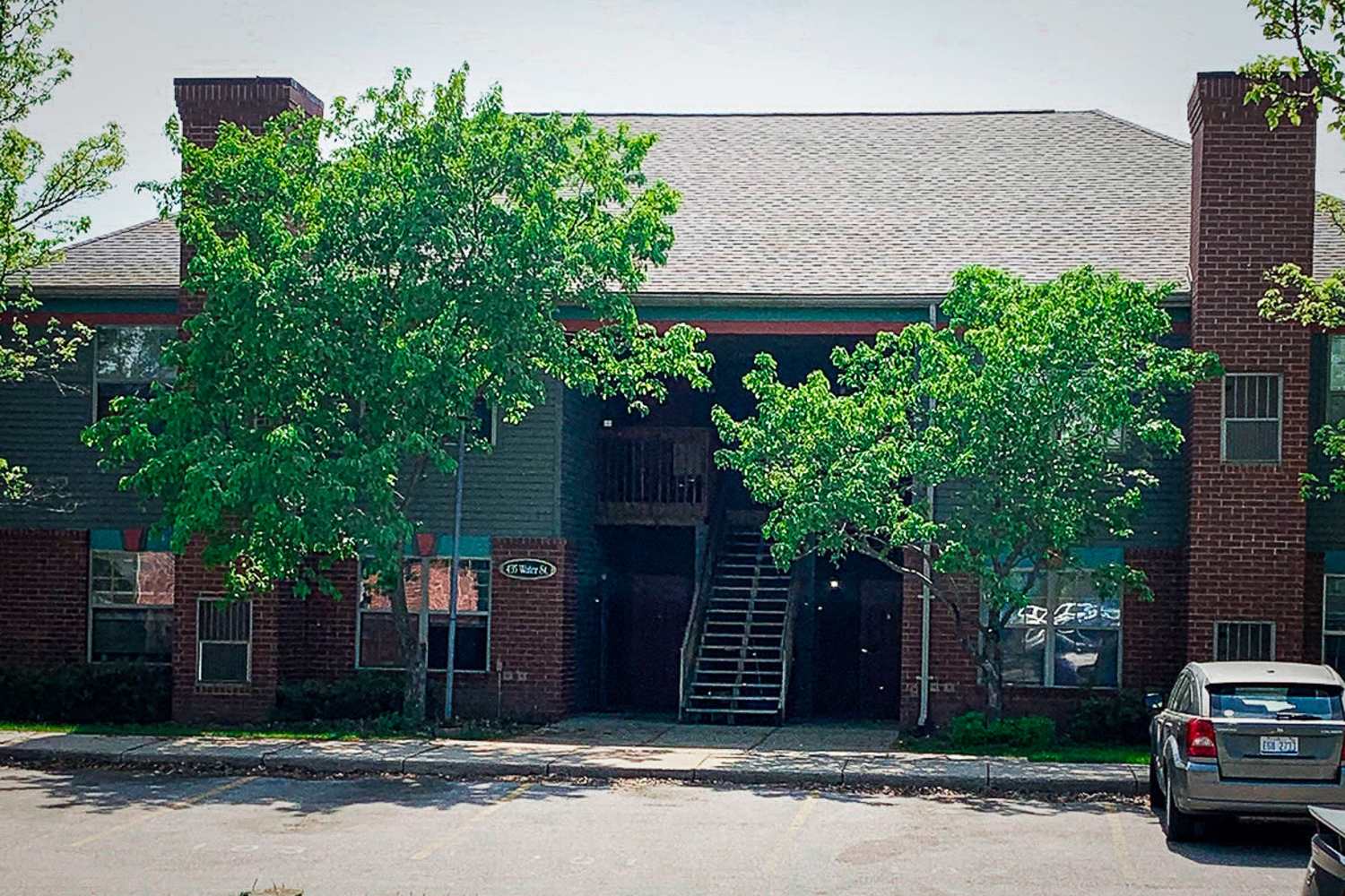 Exterior of the apartment with parking in the front at Carriage Town Square in Flint, Michigan