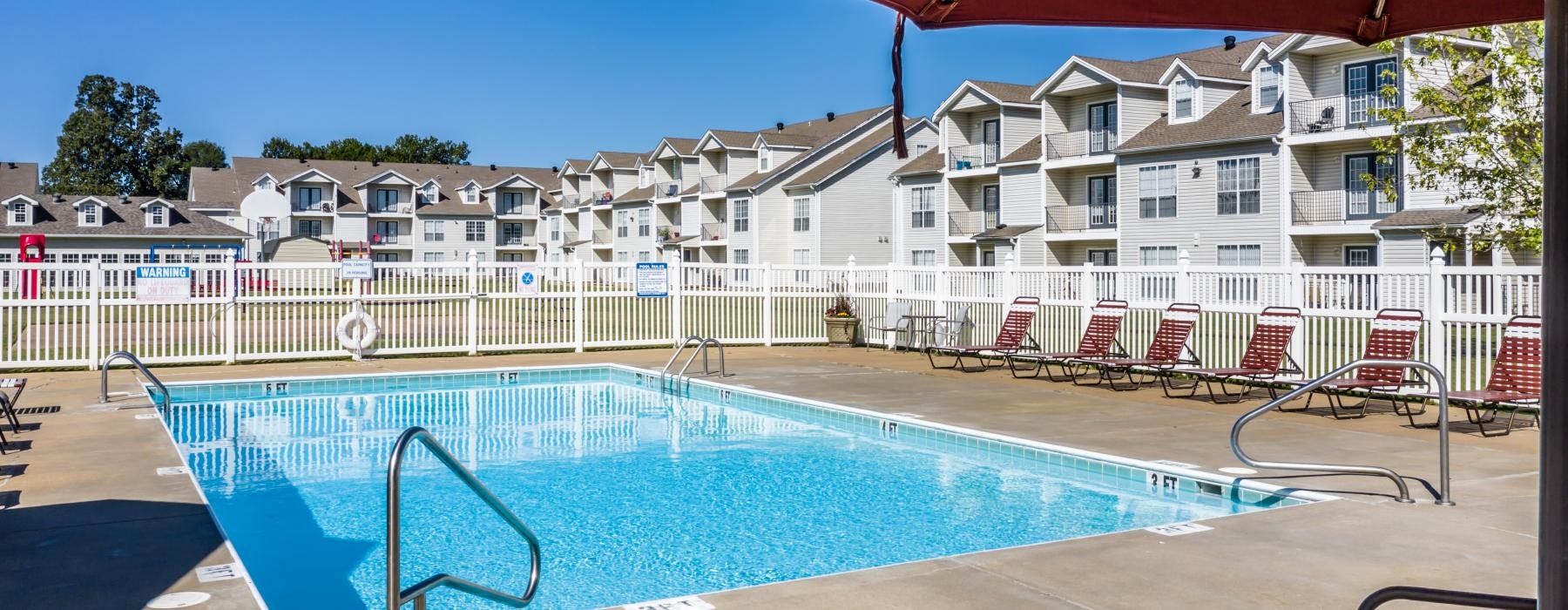 a pool with chairs and umbrellas around it