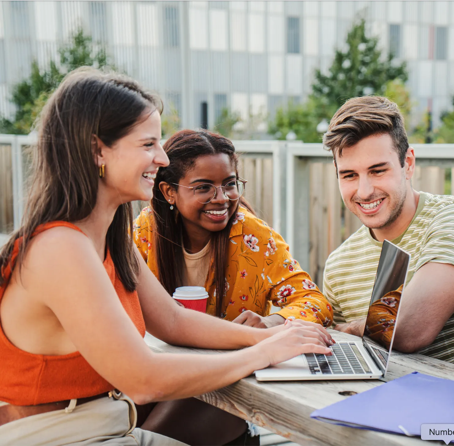 friends sitting around table with computer stock image