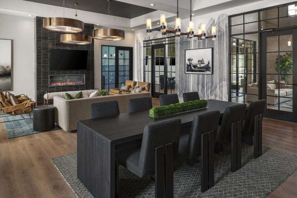 A modern dining room with a black table and chairs.