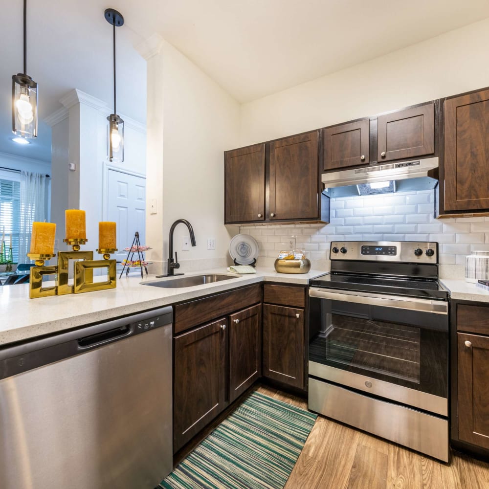 a kitchen with stainless steel appliances and wood cabinets at The  Pines on Spring Rain