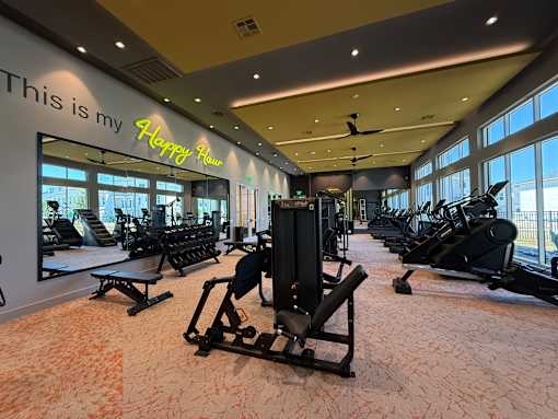 A gym with a variety of equipment including treadmills, weights, and exercise machines.