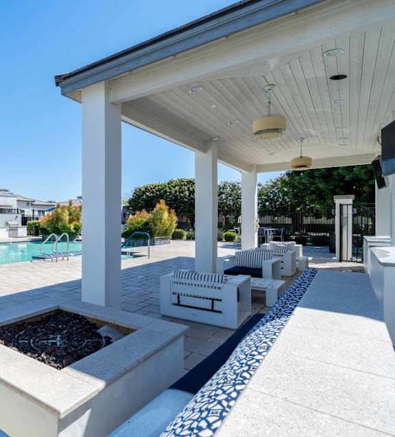 Covered outdoor patio with fire pit at Vistoria On Greenway Apartments, Surprise, Arizona