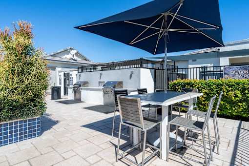 Rooftop barbecue area with dining table at Vistoria On Greenway Apartments, Surprise, Arizona