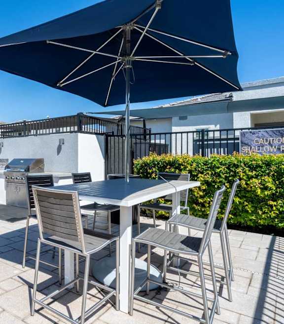 Rooftop barbecue area with dining table at Vistoria On Greenway Apartments, Surprise, AZ 85379
