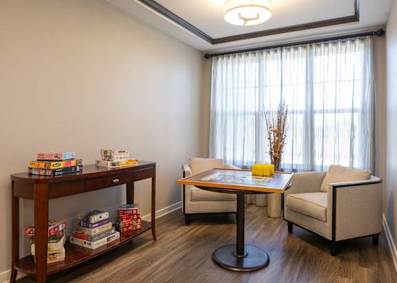 a living room with chairs and a table and a window