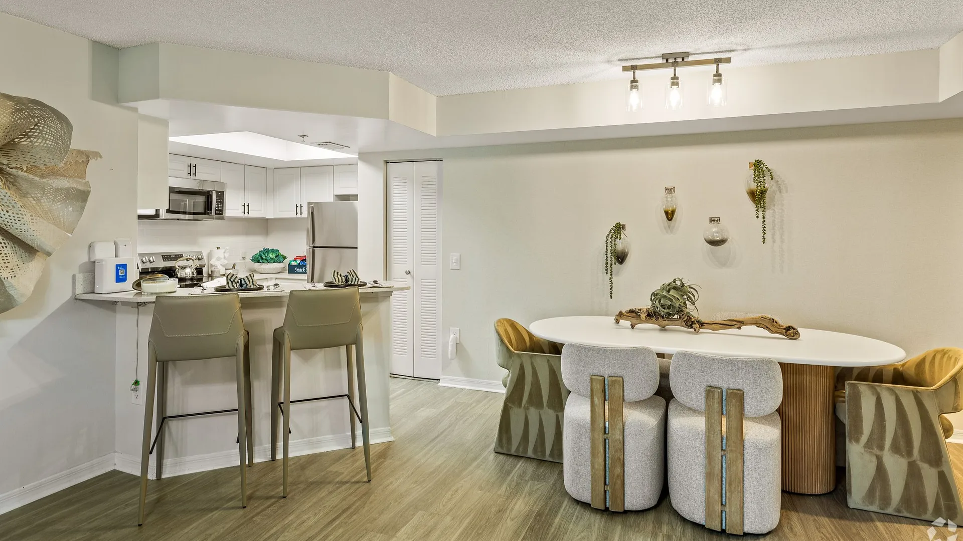 Modern dining area with a round table, stylish chairs, and a contemporary kitchen space.
