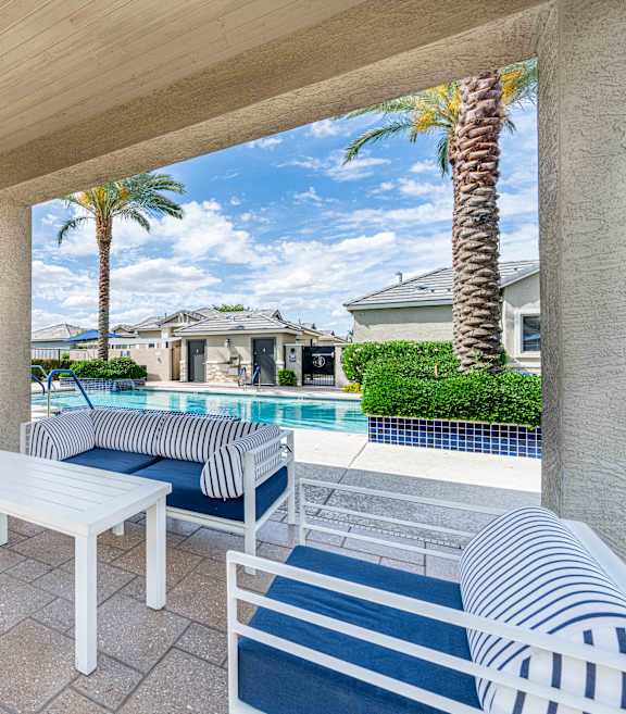A patio with a white couch, a fireplace, and a television at Vistoria At Country Place Apartments, Tolleson, 85353
