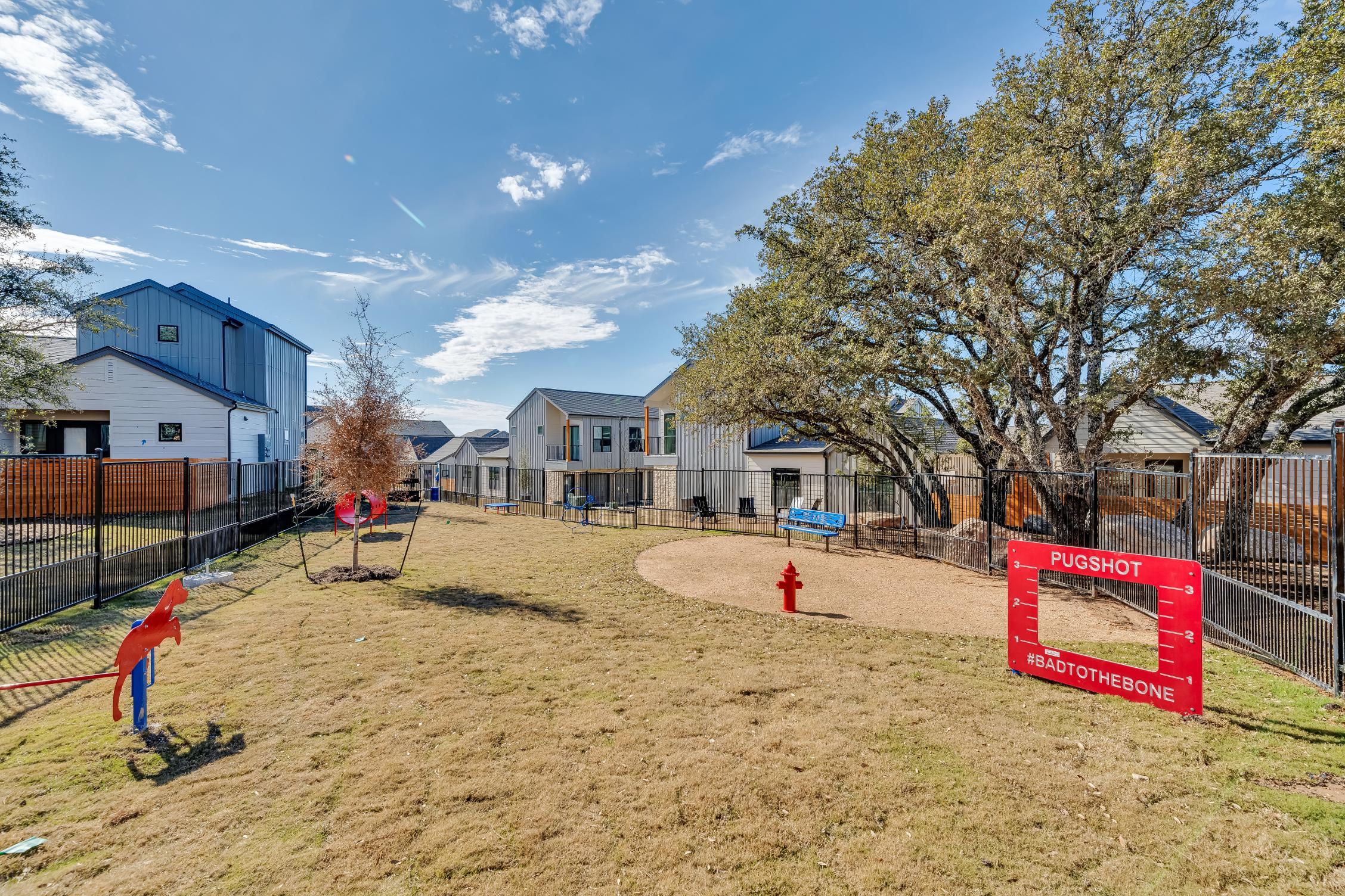 Fenced in dog park with agility course at The parcHAUS at Mustang Drive