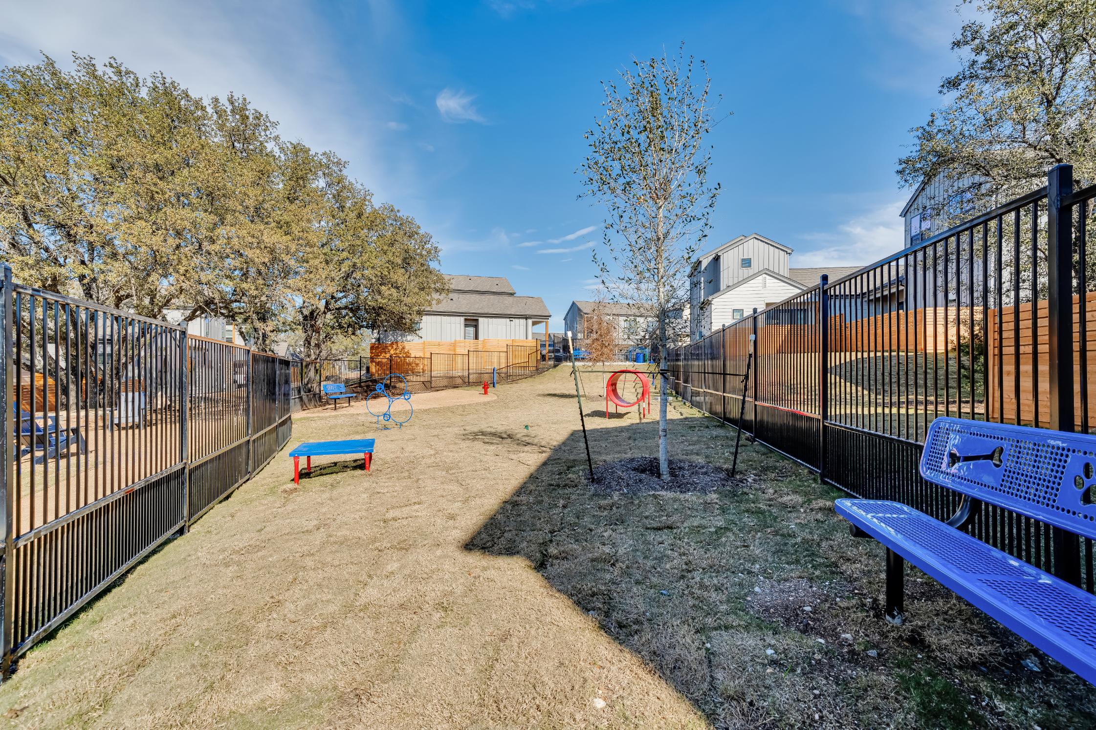 Fenced in dog park with agility course at The parcHAUS at Mustang Drive